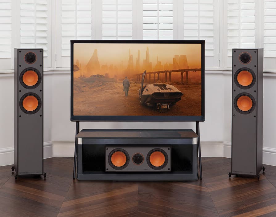 Home theatre system with two speakers and a large TV showing the post-apocalyptic movie Mad Max