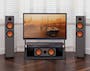 Home theatre system with two speakers and a large TV showing the post-apocalyptic movie Mad Max