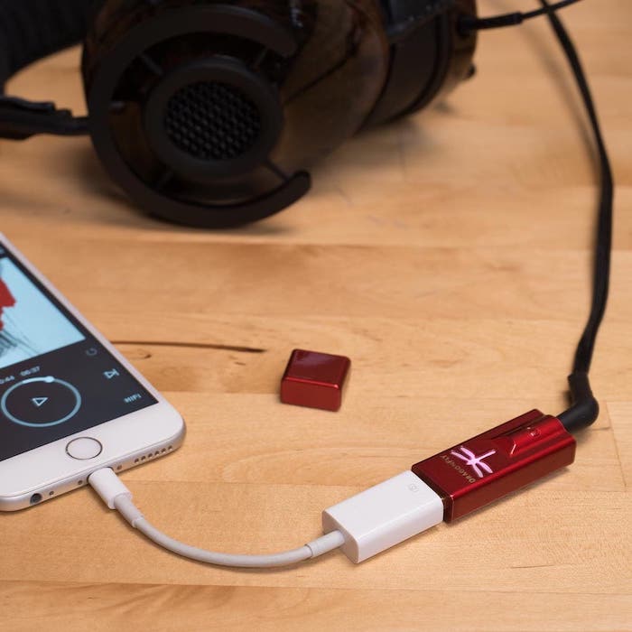 picture of headphones plugged into an audio convertor, which is then connected to an iphone.