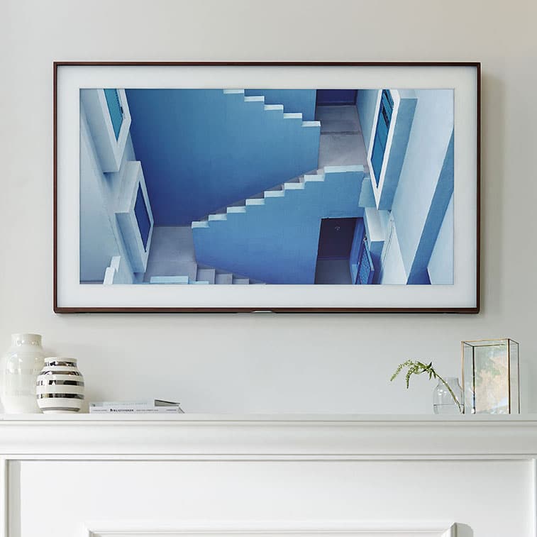 Picture of a wall-mounted TV framed in a wooden frame, looking like a picture on the wall.